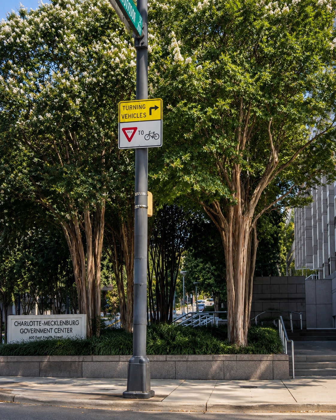 Charlotte Mecklenburg Government Center streetscape with mature trees and planted civic beds.